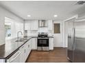 Bright kitchen with stainless steel appliances, wood-look flooring, and white cabinets at 3646 Springfield Dr, Holiday, FL 34691