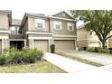 Exterior of a townhome featuring attached two-car garage and neutral color scheme at 4133 Bismarck Palm Dr, Tampa, FL 33610