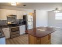Open kitchen showcasing stainless steel appliances, wooden island, and sleek countertops, perfect for cooking and entertaining at 4402 Ohio Ave, Tampa, FL 33616