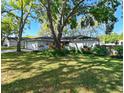 Quaint one-story home with a well-manicured lawn and garden beds, complemented by mature trees providing ample shade at 4915 Churchill Pl, Land O Lakes, FL 34639