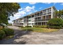 Well-maintained building exterior featuring multiple screened balconies with lush landscaping and plenty of parking at 50 Harbor View Ln # 21, Belleair Bluffs, FL 33770