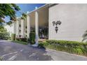 White condominium building with well manicured landscaping, tall pillars and elegant exterior lighting at 50 Harbor View Ln # 21, Belleair Bluffs, FL 33770