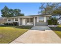 Alluring single-story home with a well-manicured lawn and inviting walkway to the front door at 6712 Runningwoods Dr, Tampa, FL 33634