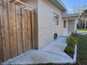 Side view of the home with a fence providing extra privacy and a pathway to the front door at 7126 Oelsner St, New Port Richey, FL 34652