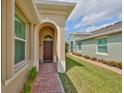 Inviting covered entryway featuring a brick walkway and a charming, dark wood front door at 807 Chipper Dr, Sun City Center, FL 33573