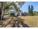 Spacious backyard with a screened-in pool area, garage, and ample green space at 13982 Whisperwood Dr, Clearwater, FL 33762