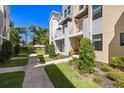 Well-manicured landscaping leads to the townhome entrance with a charming bench and covered entryway at 2570 12Th N Pl, St Petersburg, FL 33713