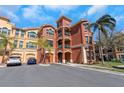 Condominium building exterior with manicured landscaping, private garages, and parking available for residents at 2730 Via Tivoli # 321B, Clearwater, FL 33764