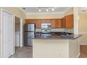 Well-equipped kitchen featuring stainless steel appliances, granite countertops, and a view of the laundry at 2730 Via Tivoli # 321B, Clearwater, FL 33764