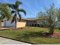 Well-maintained single-story home featuring a lush, green lawn and landscaped beds at 3120 Dole St, Holiday, FL 34691