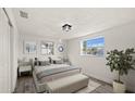 Cozy bedroom with hardwood floors, natural light from a large window, and stylish decor at 3249 Masonville Loop, Holiday, FL 34691