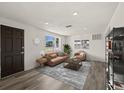Bright living room featuring modern furniture, hardwood floors, and a large window with natural light at 3249 Masonville Loop, Holiday, FL 34691