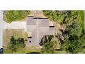 Aerial view of the home's roofline, driveway, and the surrounding yard with trees providing ample shade at 3276 Morven Dr, Spring Hill, FL 34609