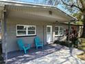 Inviting covered front porch features decorative stone accents, two blue chairs, and a bright white front door at 337 Shore E Dr, Oldsmar, FL 34677