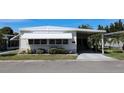 Lovely single-story home featuring a covered carport, awning, and well-maintained landscaping, creating a warm and inviting facade at 369 Cobia Way, Oldsmar, FL 34677