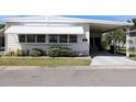Inviting single-story home with a covered carport, awning, and manicured landscaping, offering a cozy and appealing exterior at 369 Cobia Way, Oldsmar, FL 34677