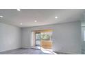 Bright living room featuring new gray wood-look floors and a sliding glass door to the outside at 4004 Cortez Dr # D, Tampa, FL 33614