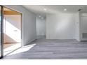 Bright living room featuring new gray wood-look floors, fresh paint, and a sliding glass door to the outside at 4004 Cortez Dr # D, Tampa, FL 33614