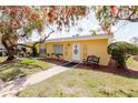 Bright yellow house with decorative trees and a bench near the front door, offering curb appeal at 401 Dorchester Pl # 55, Sun City Center, FL 33573