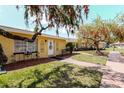 A yellow house with a walkway and decorative trees giving a lovely view at 401 Dorchester Pl # 55, Sun City Center, FL 33573