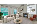 Bright living room with a modern fireplace, large windows, and cozy furniture at 5014 Sterling Manor Dr, Tampa, FL 33647