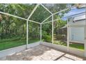 Relaxing screened porch with tile flooring, offering serene views of the backyard's natural greenery at 5014 Sterling Manor Dr, Tampa, FL 33647