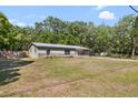 A single story house with green grass, green siding and a metal roof at 509 Faithway Dr, Seffner, FL 33584