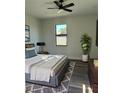 Cozy bedroom with a comfortable bed, soft lighting, sleek ceiling fan, and a view from the window at 5166 Deltona Blvd, Spring Hill, FL 34606