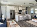 A stylish kitchen with modern appliances, pendant lighting, and an open concept to the living room at 5166 Deltona Blvd, Spring Hill, FL 34606