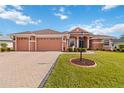 Inviting single-story home featuring a lush green lawn, brick driveway, and a welcoming facade at 5444 90Th Avenue E Cir, Parrish, FL 34219