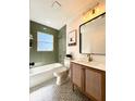 Stylish bathroom featuring green tiled walls, a shower-tub combo, and modern vanity at 6710 N 13Th St, Tampa, FL 33604