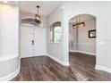 Bright foyer with beautiful wood floors, elegant lighting and arched entryways to adjacent rooms at 7214 Yardley Way, Tampa, FL 33647