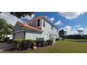 View of the side and rear of the house showing the lawn, landscaping and golf course at 7279 Maidencane Ct, Seminole, FL 33777