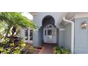 Close up of the front door of the house with a tiled walkway and landscaping at 7279 Maidencane Ct, Seminole, FL 33777