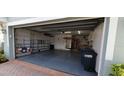 View of the garage with open door, storage cabinets, and door to the house at 7279 Maidencane Ct, Seminole, FL 33777