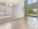 Bright living room with light gray walls, high ceilings, and a sliding glass door to the exterior at 8314 Deerland Bluff Ln, Riverview, FL 33578