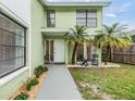 Inviting home entrance with a walkway, a small lawn, and chairs to enjoy the outdoors at 10306 Green Grove Pl, Tampa, FL 33624