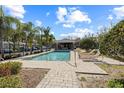 Community pool featuring lounge chairs, a shaded gathering area, and fenced surround at 11047 Black Swan Ct, Seffner, FL 33584