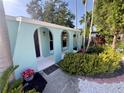 Covered front porch with decorative arched entryways and a garden featuring tropical plants at 1754 Patricia Ave, Dunedin, FL 34698