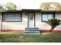 Inviting front entrance with updated steps, windows, and landscaping around the perimeter at 19455 Fort Dade Ave, Brooksville, FL 34601