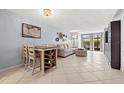 Open living room featuring tile flooring, light blue walls, a dining area, and a sliding glass door to the porch at 1986 Pelican Landing Blvd # 1514, Clearwater, FL 33762