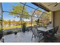 Screened lanai offers picturesque water view with outdoor dining set and retractable awning for comfortable entertaining at 21205 Calle Rosa Dr # 10, Land O Lakes, FL 34637