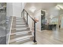 Illuminated staircase with wood-look floors leads to an open floor plan with kitchen island and black stainless appliances at 21205 Calle Rosa Dr # 10, Land O Lakes, FL 34637