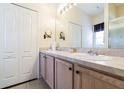 Bathroom featuring double sinks, wood cabinets, and a large mirror, with a shower in the background at 2514 Sandy Hill Ct, Holiday, FL 34691