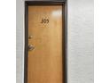 Front door of unit 305 with visible unit number on a textured wall at 2595 Countryside Blvd # 8-305, Clearwater, FL 33761