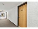 Hallway view leading to unit 305 with neutral colored carpet and textured walls at 2595 Countryside Blvd # 8-305, Clearwater, FL 33761