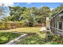 Lush green backyard with a well-maintained lawn and wooden fence, with access to a screened-in porch at 3609 S Omar Ave, Tampa, FL 33629