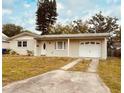 Single-story home with a driveway, attached garage, and neutral exterior paint at 4033 Newcastle Dr, New Port Richey, FL 34652
