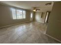 Interior features tiled flooring and neutral paint, along with a ceiling fan and large window at 4033 Newcastle Dr, New Port Richey, FL 34652