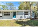 Close-up of a tidy single-story home with a blue front door and light grey exterior at 4421 W Iowa Ave, Tampa, FL 33616